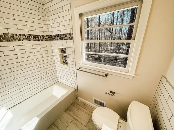 a bathroom with a toilet and a shower