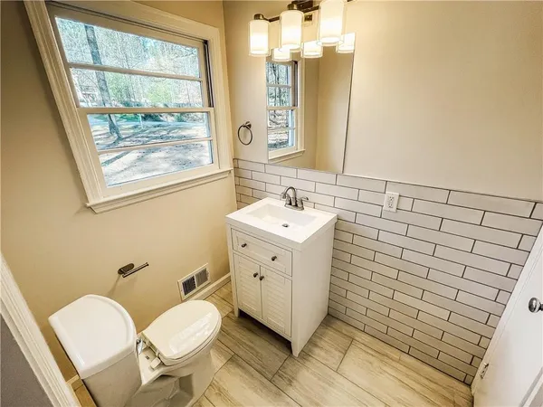 a bathroom with a sink mirror vanity and toilet