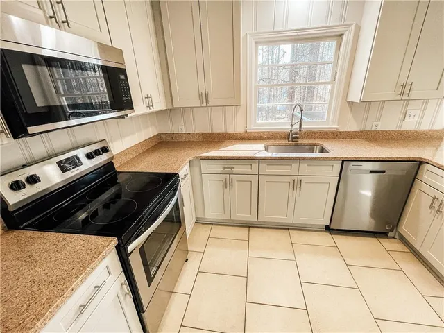 a kitchen with a stove a sink and a microwave