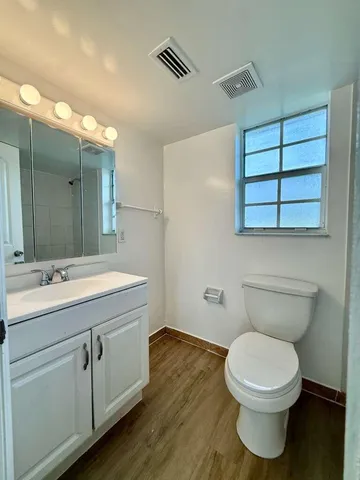 a bathroom with a toilet sink and mirror