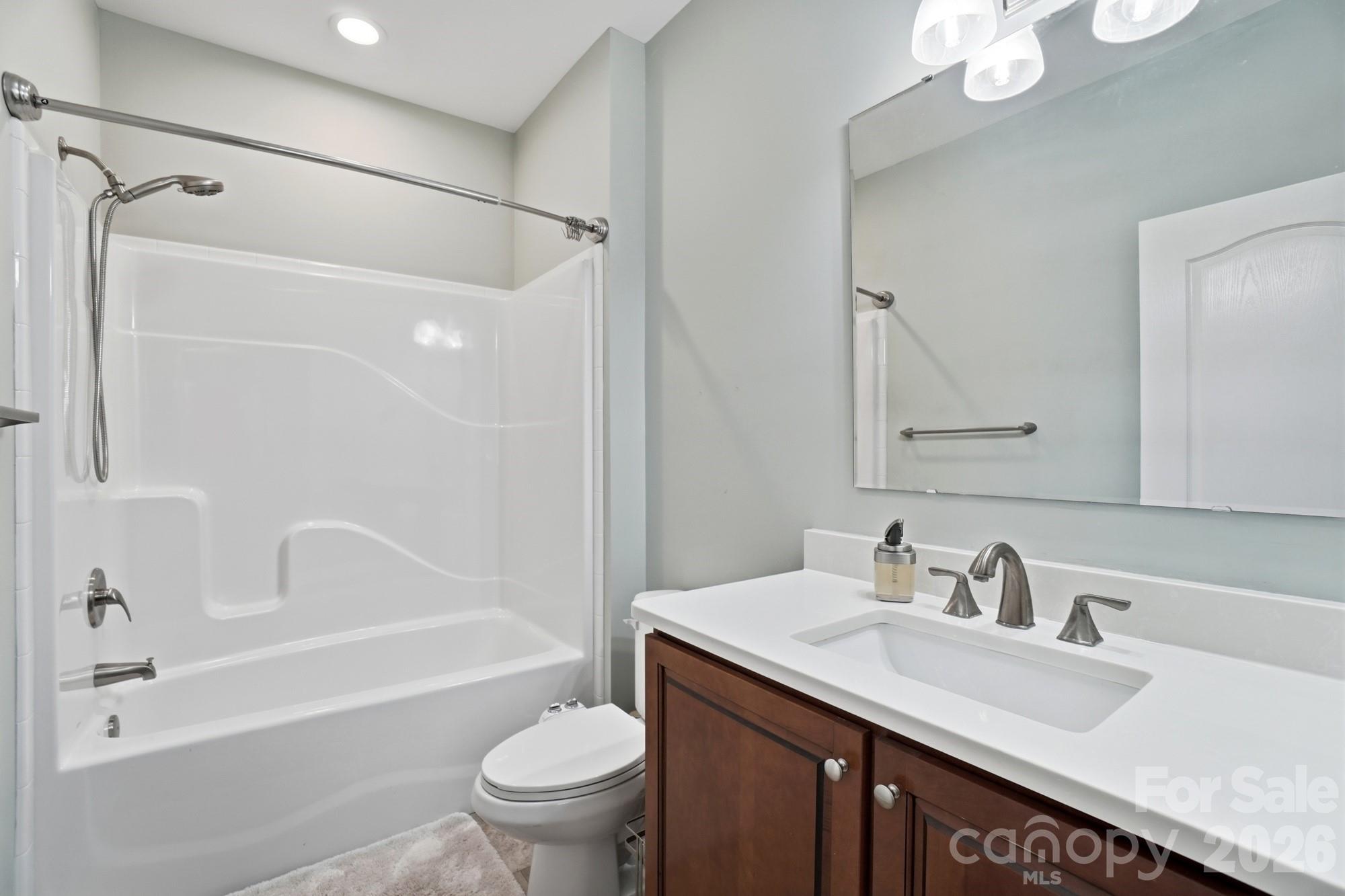4363 Grace Church Road Newton, NC 28658 - Photo 20 of 30 a bathroom with a granite countertop sink toilet and shower