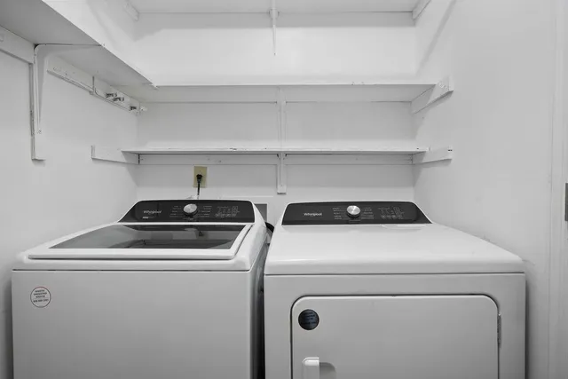 a view of washer and dryer with kitchen in the background