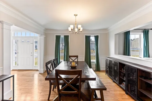 a view of a a dining room with furniture window and wooden floor