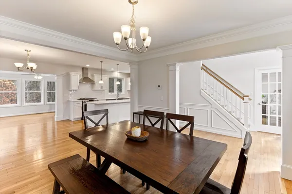a view of a dining room with furniture a chandelier and wooden floor