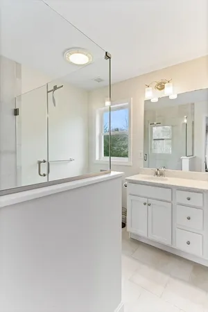 a bathroom with a double vanity sink and mirror with bathtub