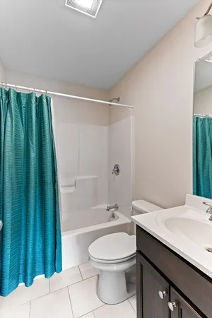 a bathroom with a granite countertop bathtub sink vanity mirror and toilet