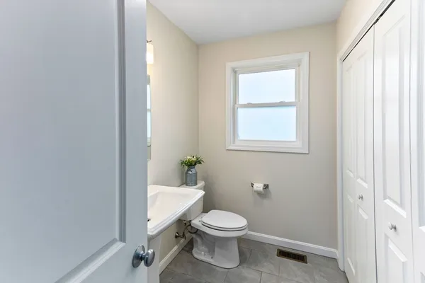 a bathroom with a toilet a sink and window