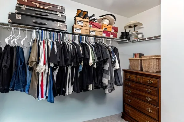 a view of walk in closet with clothes and shoes