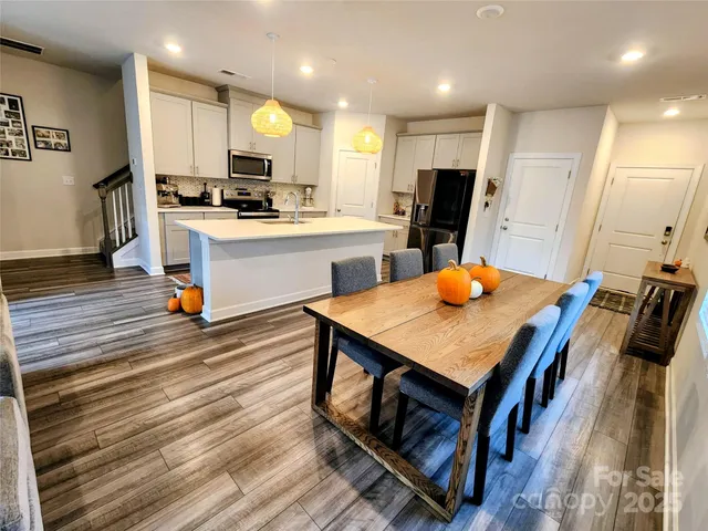 a kitchen with stainless steel appliances a stove refrigerator and wooden floor