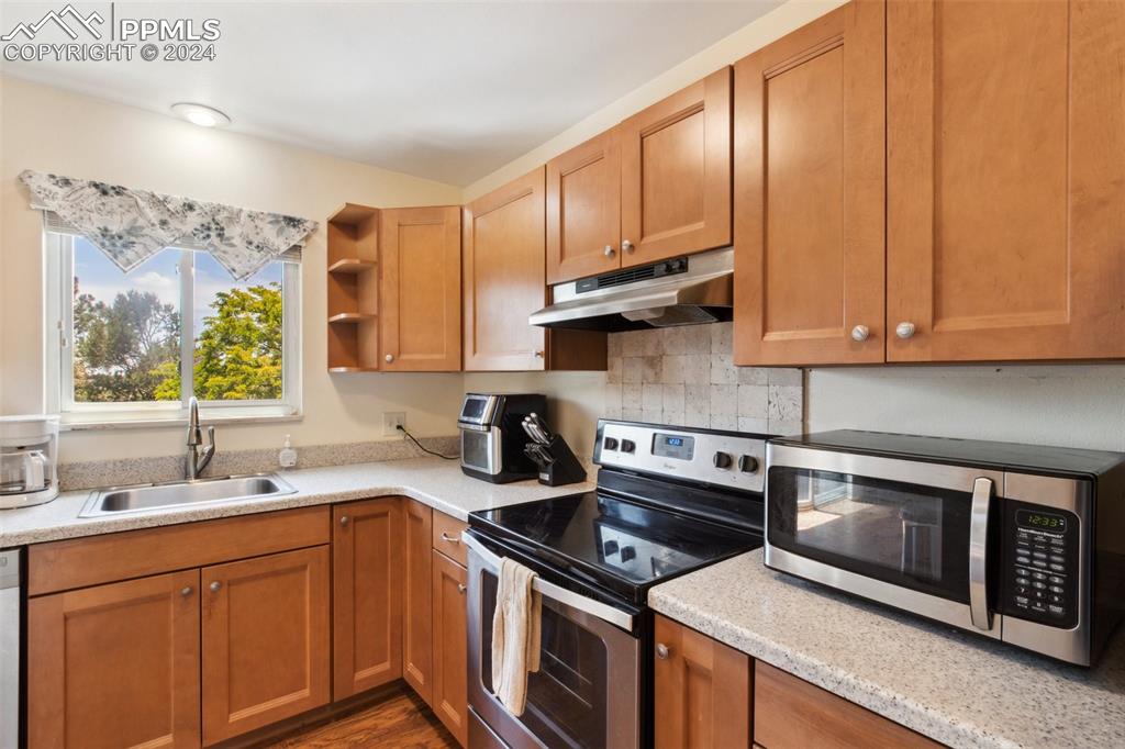 2927 Mesa Road, Unit C Colorado Springs, CO 80904 - Photo 12 of 34 a kitchen with stainless steel appliances granite countertop a sink stove and microwave