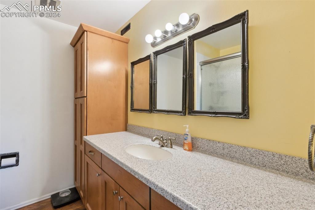 2927 Mesa Road, Unit C Colorado Springs, CO 80904 - Photo 21 of 34 a bathroom with a granite countertop sink and a mirror