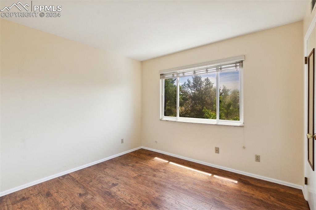 2927 Mesa Road, Unit C Colorado Springs, CO 80904 - Photo 22 of 34 a view of an empty room with wooden floor and a window