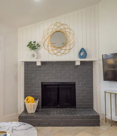 a living room with furniture a flat screen tv and a fireplace