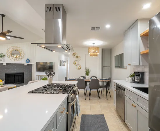 a kitchen with stainless steel appliances a sink a refrigerator and cabinets