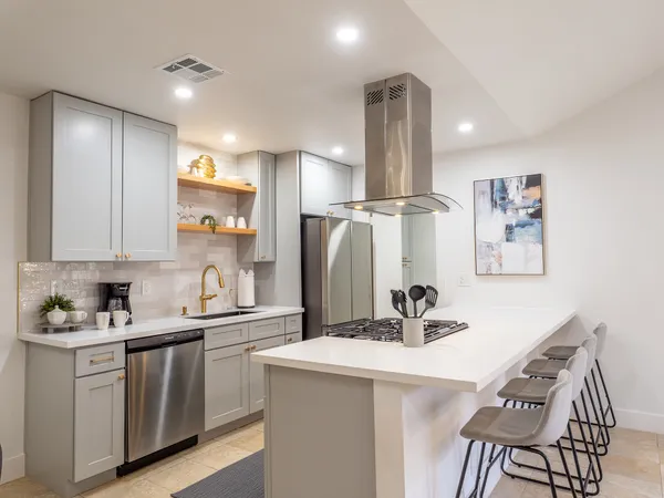 a kitchen with stainless steel appliances granite countertop a sink a refrigerator and a refrigerator