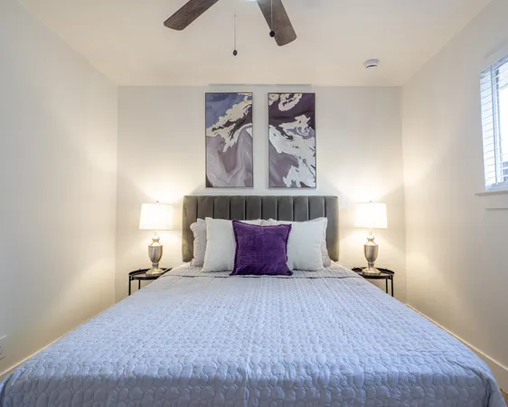 a bedroom with a bed and painting on the wall