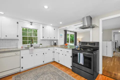 a kitchen with granite countertop a stove top oven sink and cabinets