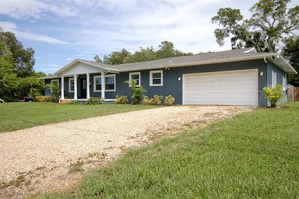 a front view of a house with yard and green space