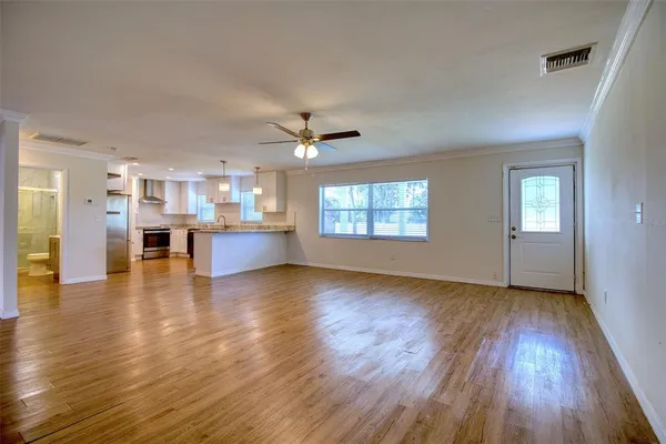 wooden floor in an empty room with a kitchen
