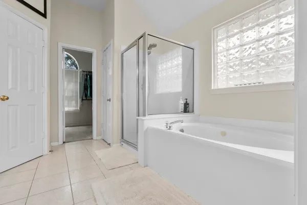 a spacious bathroom with a shower a sink and a mirror