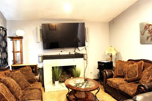 a living room with furniture a fireplace and a flat screen tv