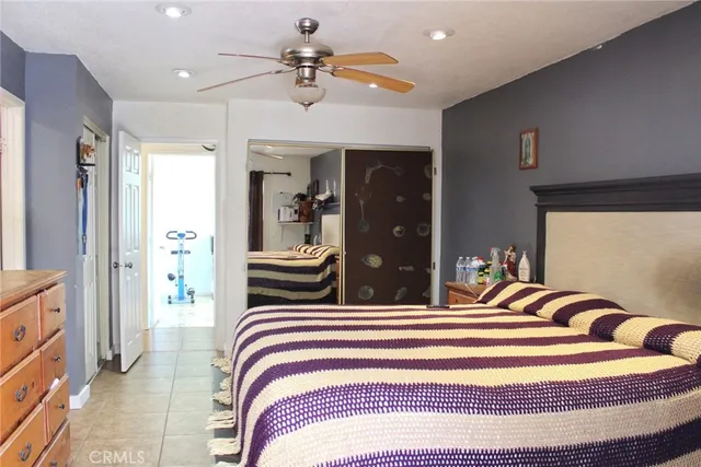 a bedroom with a bed and ceiling fan