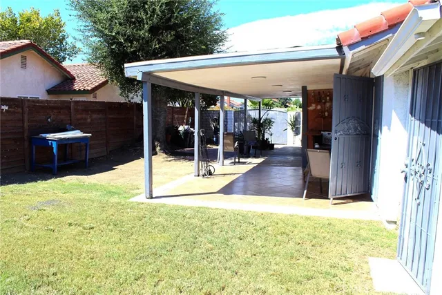 a view of a patio with table and chairs and wooden fence