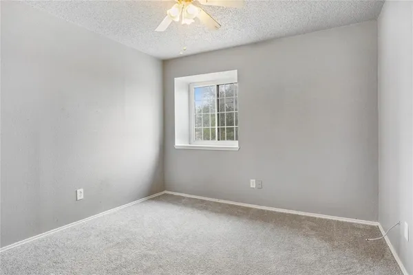 an empty room with a chandelier fan