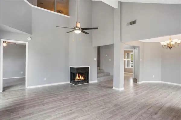an empty room with wooden floor a fireplace and a window