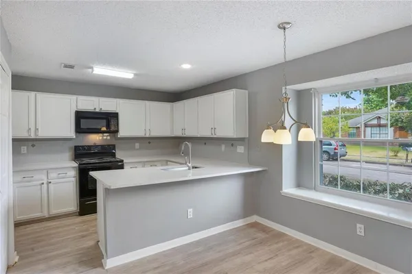 a kitchen with stainless steel appliances granite countertop a sink a stove and a refrigerator