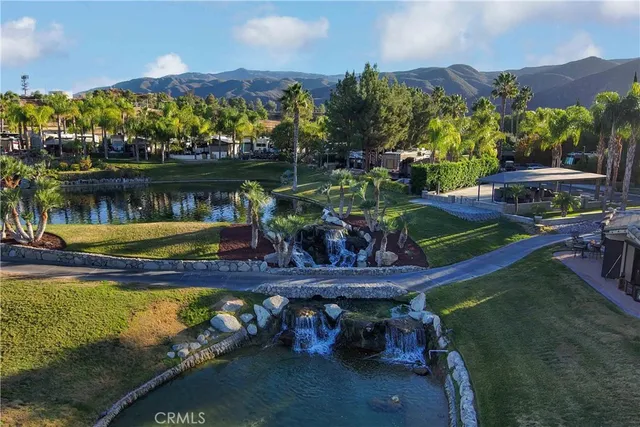 a view of a small yard in front of a house with a lake view