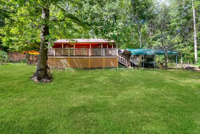 a view of a deck with a big yard and large trees