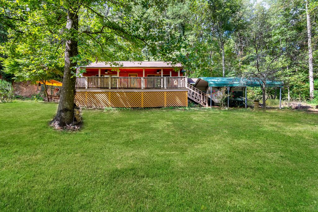 a view of a deck with a big yard and large trees