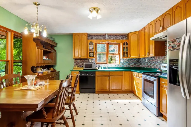 a kitchen with granite countertop a sink stove and refrigerator