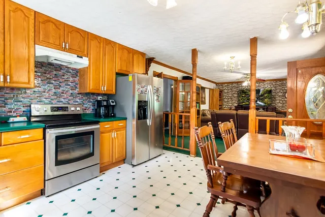 a kitchen with stainless steel appliances a stove a sink dishwasher and a refrigerator with wooden floor
