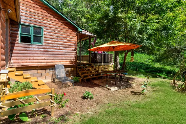a view of a house with backyard and sitting area