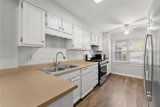 a kitchen with granite countertop a sink stainless steel appliances and cabinets
