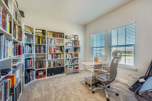 a view of a workspace with furniture and a bookshelf