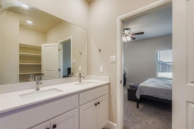 a en suite bathroom with a double vanity sink and mirror