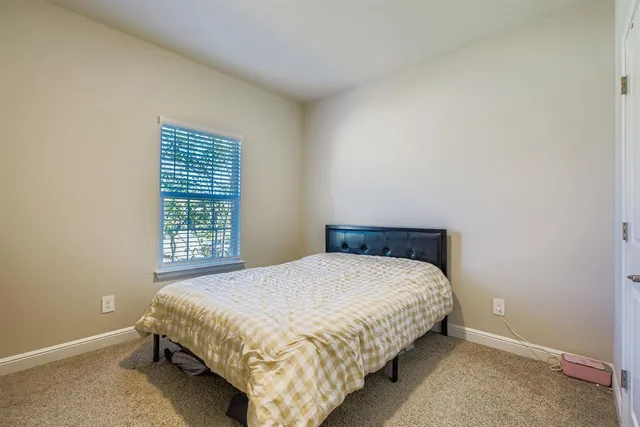 a bed sitting in a bedroom next to a window