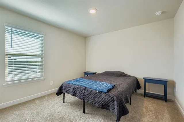 a bedroom with a bed a lamp and a window