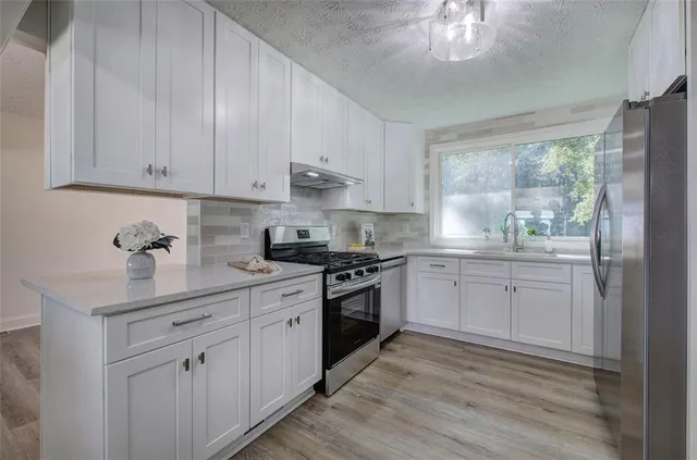 a kitchen with a white cabinets and window