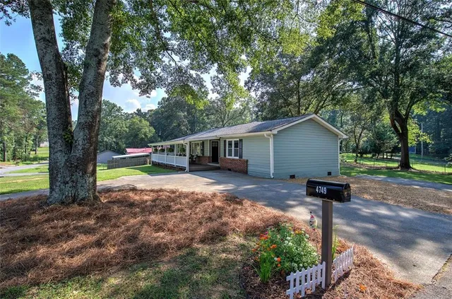 a view of a house with a backyard and a tree