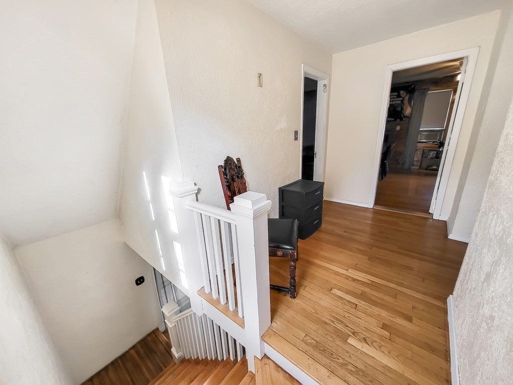 77 Olean Street Worcester, MA 01602 - Photo 21 of 42 a view of a hallway with wooden floor and stairs