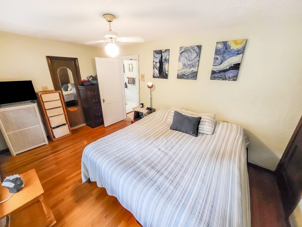 77 Olean Street Worcester, MA 01602 - Photo 27 of 42 a bedroom with a bed and wooden floor