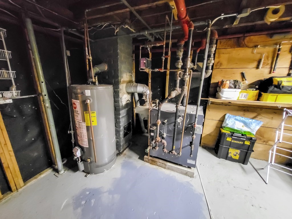 77 Olean Street Worcester, MA 01602 - Photo 42 of 42 a view of a storage room with water heater and chairs