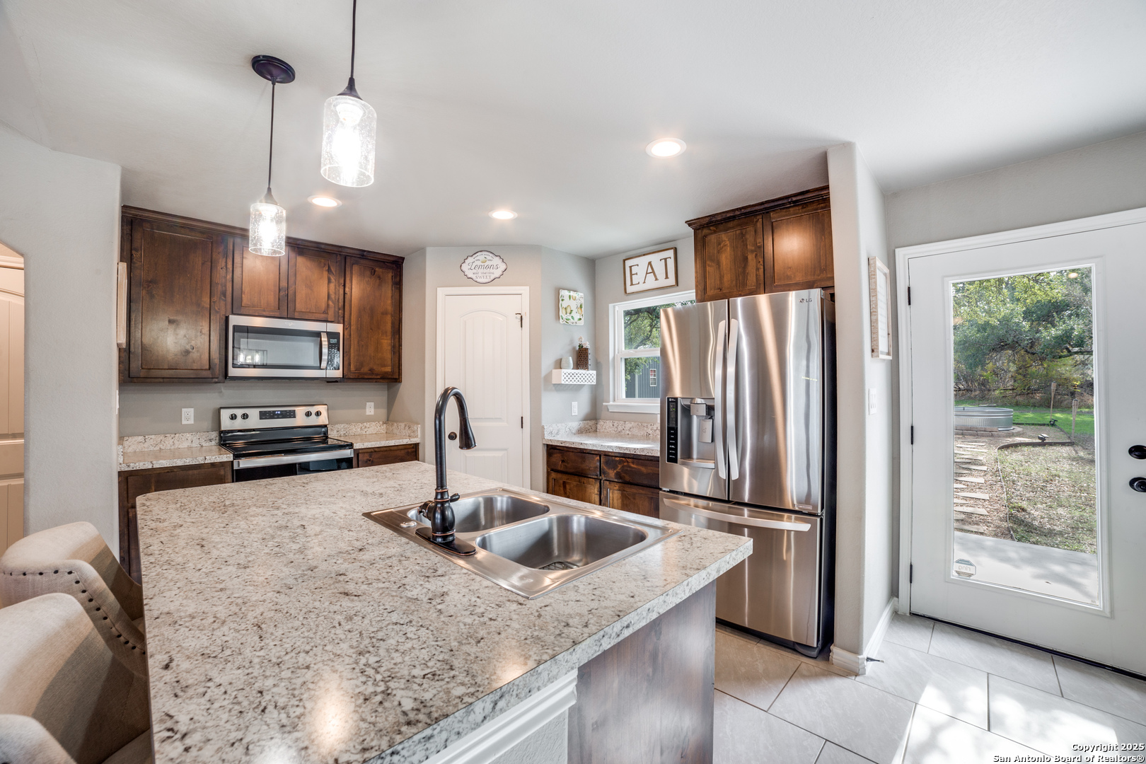 388 Bluff View Drive Spring Branch, TX 78070 - Photo 11 of 25 a kitchen with stainless steel appliances granite countertop a refrigerator a sink a stove a washer and dryer