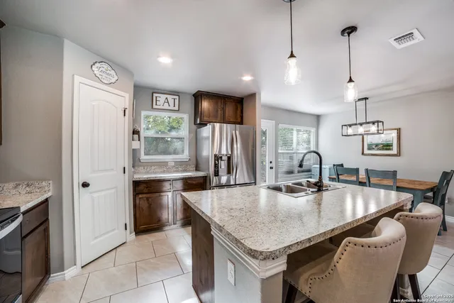 a kitchen with stainless steel appliances granite countertop a sink refrigerator and cabinets