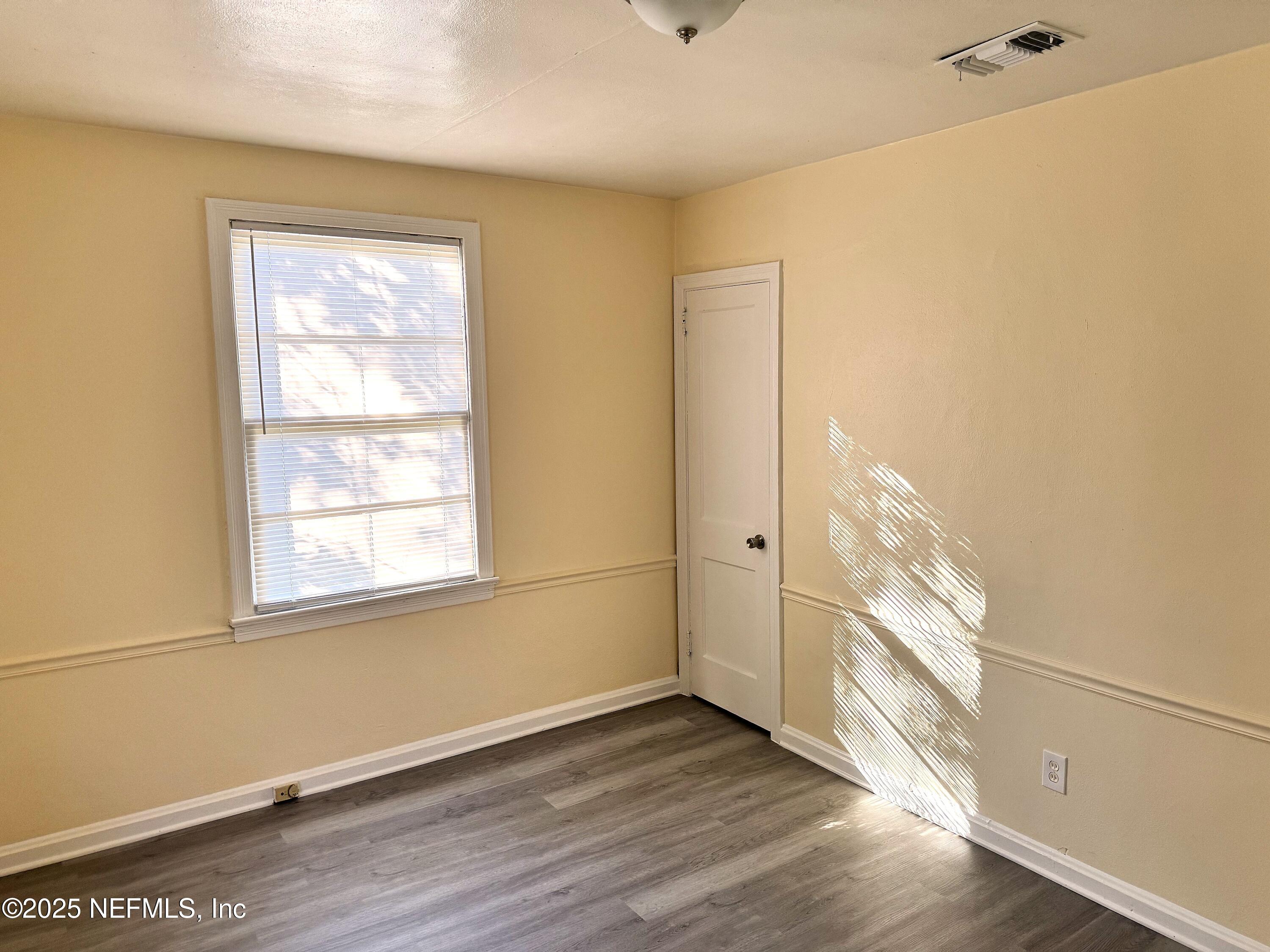 4752 Post Street Jacksonville, FL 32205 - Photo 5 of 8 an empty room with wooden floor and windows