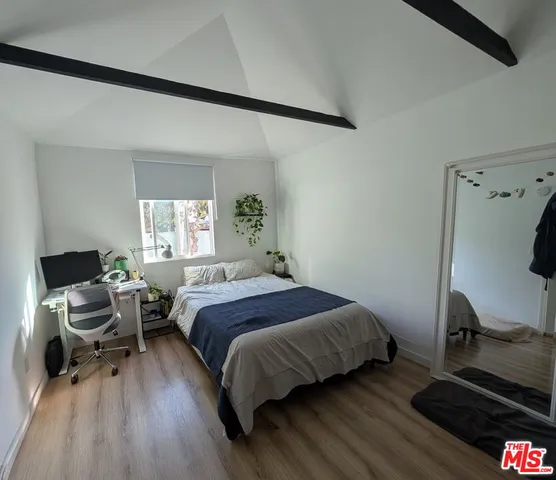 a bedroom with a bed and wooden floor